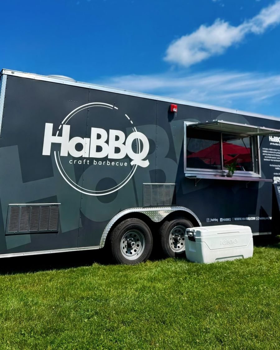 The HaBBQ craft barbecue trailer parked on grass with its serving window open