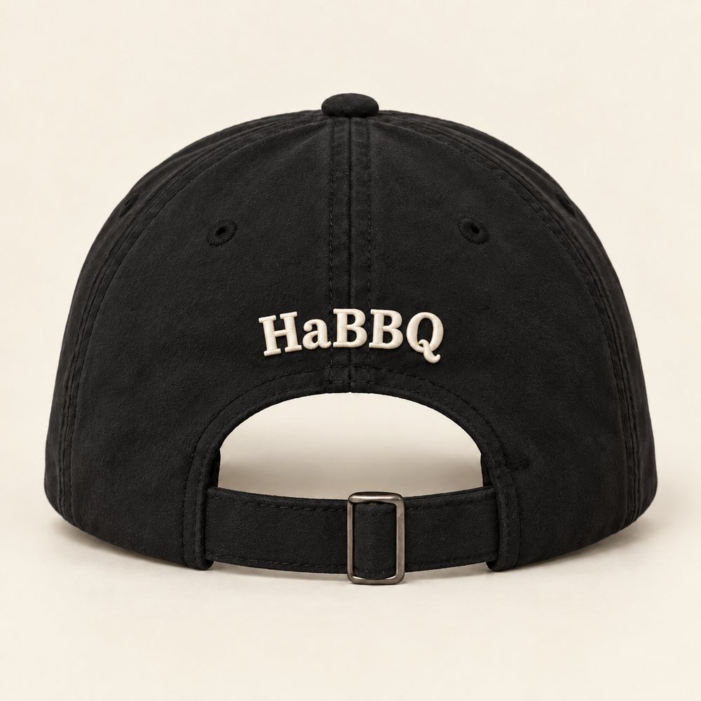 Black Sueded Cap in black with warm cream embroidery, back view with the small HaBBQ mark above the fabric strap and slide buckle