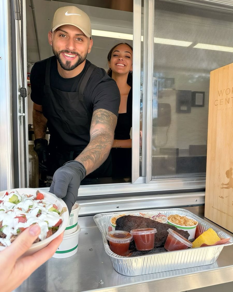 Jordan and Mercedes handing an order out of the HaBBQ trailer window